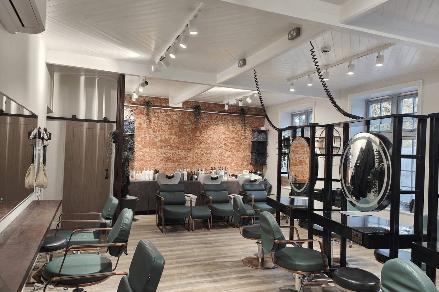 Salon interior at re:new Hair & Beauty in Woodhall Spa, with exposed brick, styling chairs and mirrors