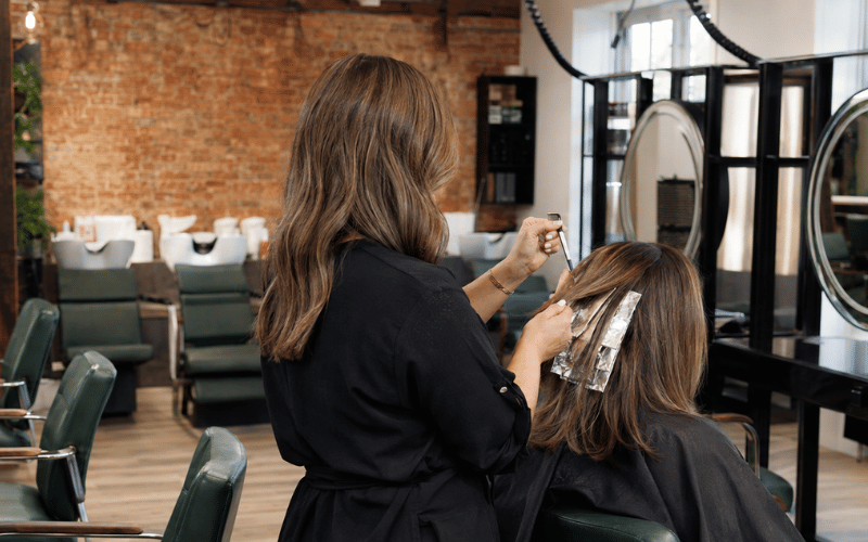 Hair stylist applying dimensional foils to brunette hair at re:new salon in Woodhall Spa