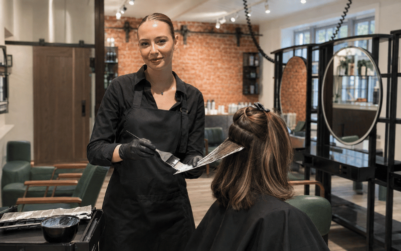 Junior stylist applying dimensional hair colour with foils at re:new salon in Woodhall Spa