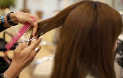 Professional stylist cutting a client’s long brown hair at re:new Hair & Beauty in Woodhall Spa