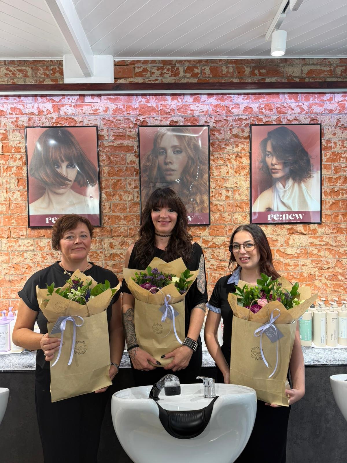 Wendy, Demi and Laurie holding flowers to celebrate their promotions at re:new Hair & Beauty in Woodhall Spa